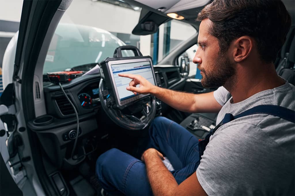 auto-mechanic-providing-car-diagnostics-in-cabin-Large