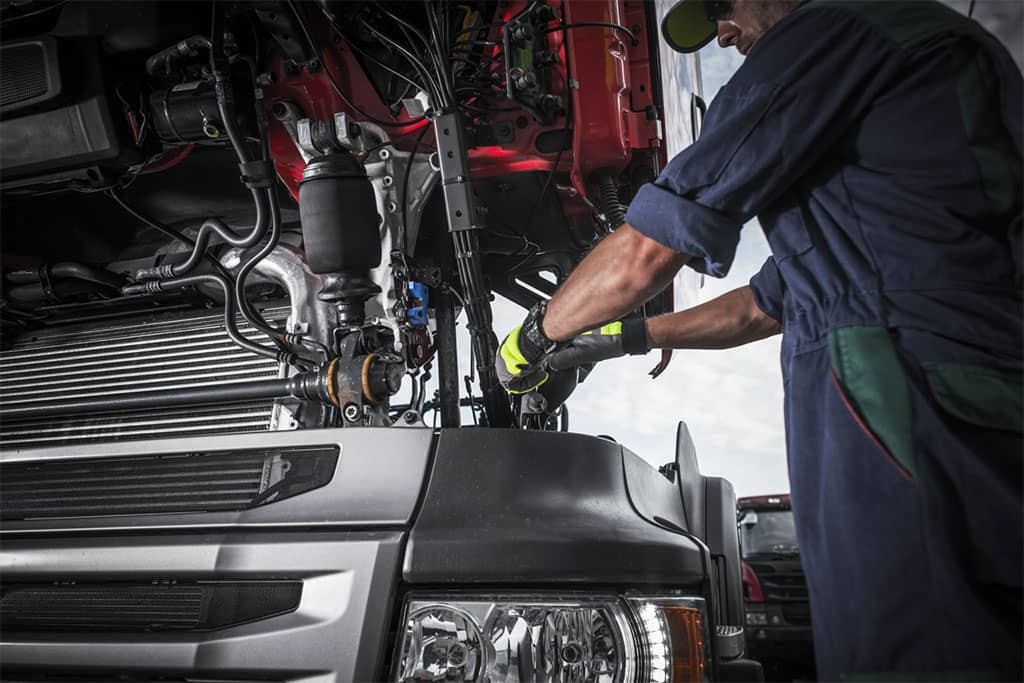The-Road-to-Success-The-Importance-of-Preventative-Maintenance-in-Trucking-Companies-repairing-broken-semi-truck